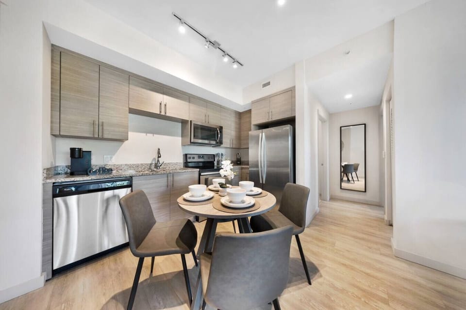 Stylish Kitchen & Dining Area- Modern kitchen with stainless steel appliances, sleek cabinetry, and a cozy dining setup for four—ideal for home-cooked meals and shared gatherings.