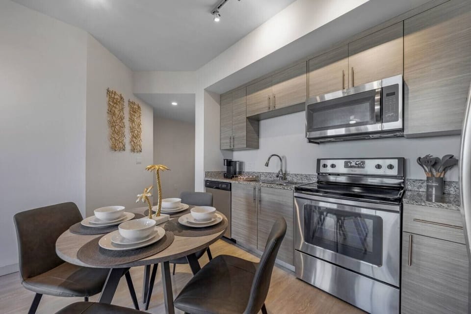 Stylish Kitchen & Dining Area-Fully equipped kitchen with stainless steel appliances, granite countertops, and ample cabinet space. Cozy dining table set for four, perfect for meals or casual gatherings.