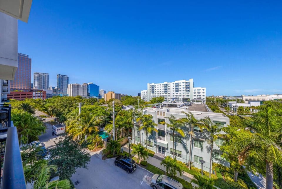 City View from Balcony-Enjoy stunning views of the city skyline and lush palm trees from the private balcony, offering a perfect spot to relax and take in the vibrant surroundings.
