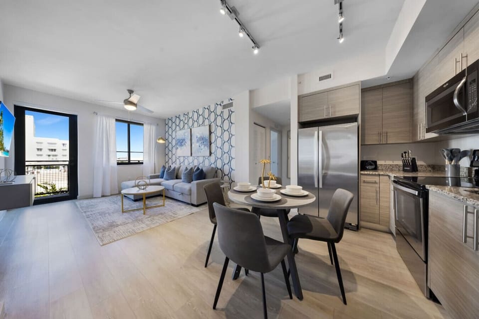 Bright Open-Concept Living-Inviting apartment with natural light, a chic dining area, and modern kitchen. Comfortable seating, stylish décor, and balcony views create the perfect space for both relaxation and dining.