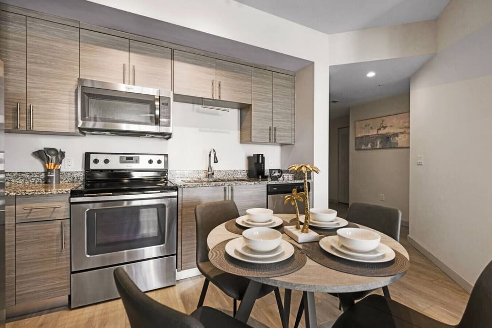 Modern Kitchen & Dining Area-Fully equipped kitchen with stainless steel appliances, sleek cabinetry, and granite countertops. Includes a cozy dining setup for four, perfect for meals and gatherings.