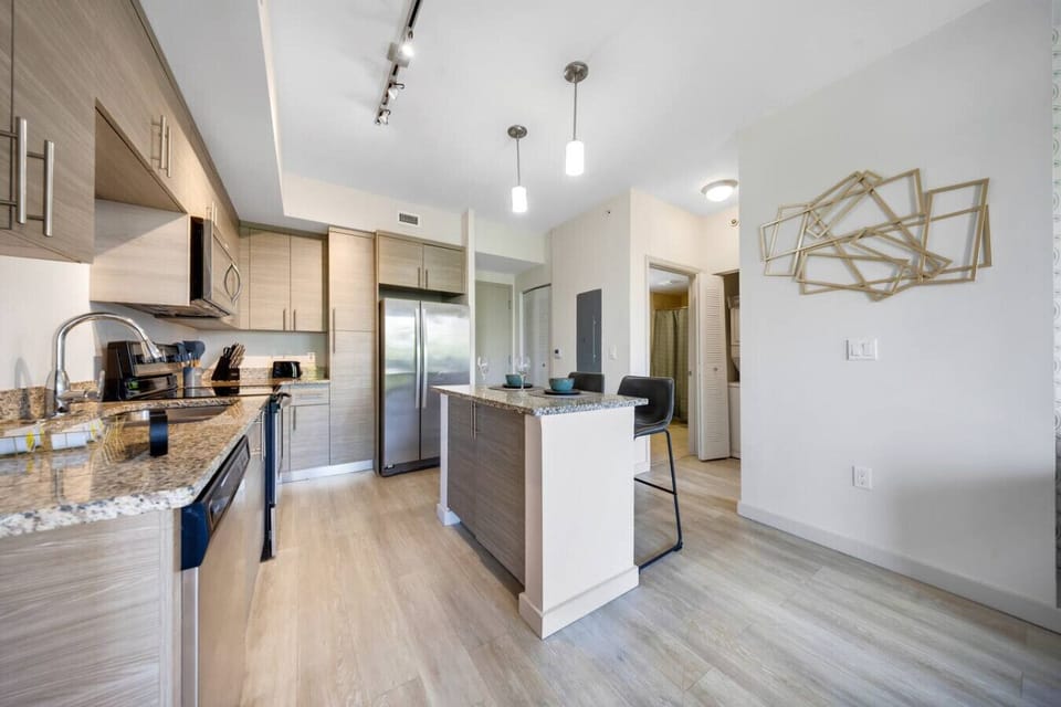 Contemporary Kitchen with Island-Sleek kitchen design with granite countertops, stainless steel appliances, and a central island with seating. Bright and modern, perfect for cooking and dining in style.