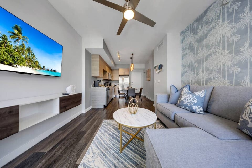 Cozy Living Space-Bright living room with modern décor, smart TV, and access to the bedroom. Features a chic coffee table, comfy seating, and natural light—perfect for relaxing after a day out.