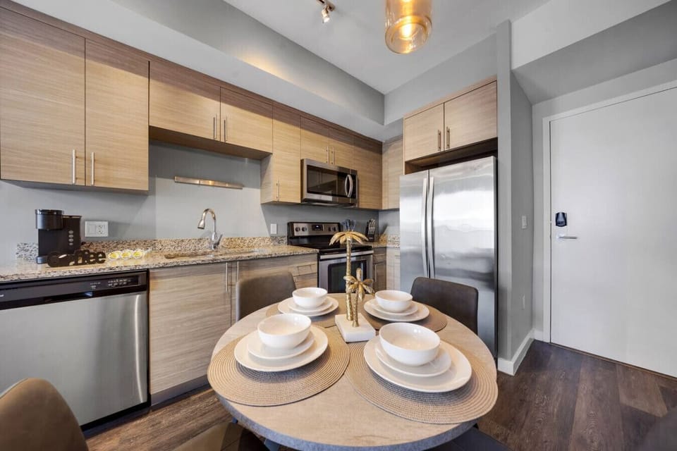 Contemporary Kitchen-Fully equipped kitchen with stainless steel appliances, sleek cabinetry, and granite countertops. Includes a dining table set for four, perfect for both everyday meals and entertaining.