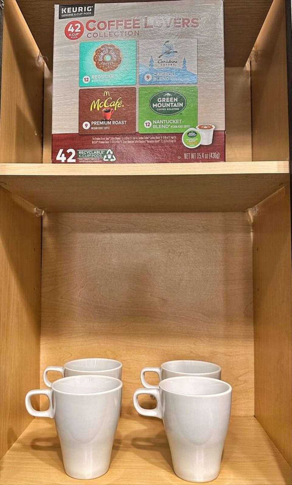 Coffee Essentials-Cabinet stocked with McCafé pods and mugs, ready for your morning brew. Convenient setup to enjoy a fresh cup of coffee during your stay.