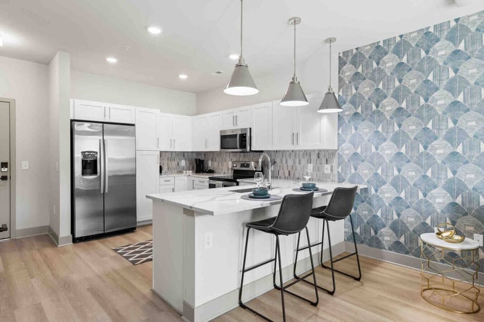 Bright Kitchen with Breakfast Bar-Stylish kitchen with stainless steel appliances, white cabinetry, and a spacious island with bar seating—perfect for casual meals or entertaining.