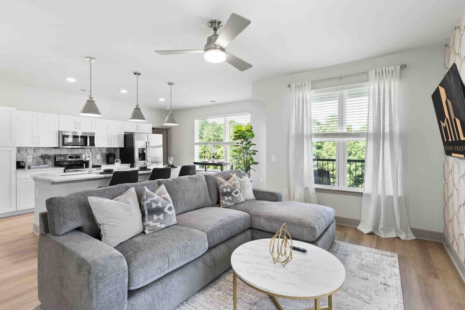 Cozy Living Room-Inviting living space with a plush sectional, modern décor, and open layout connecting seamlessly to the kitchen and dining area.