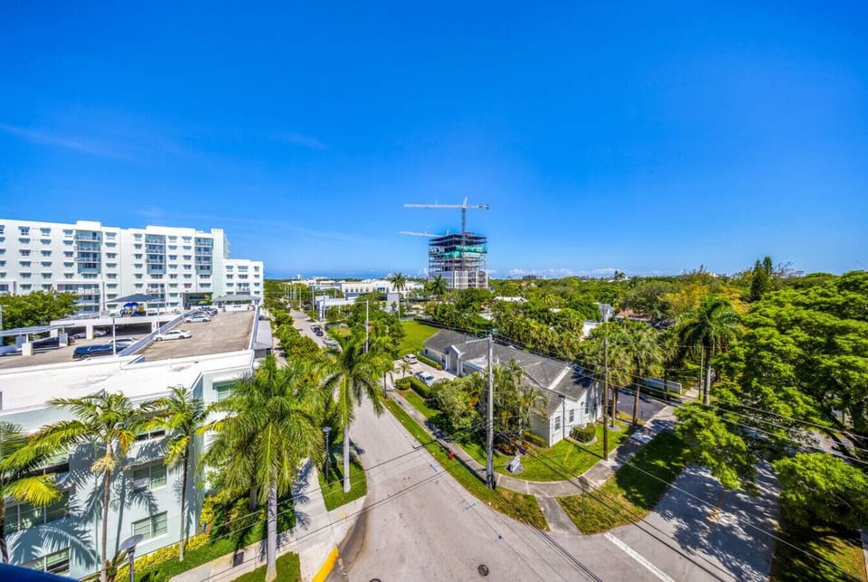 Neighborhood City View-Vibrant cityscape with palm-lined streets, modern buildings, and a clear blue sky—captured perfectly from the balcony vantage point.