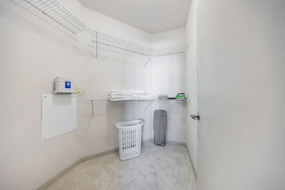 Spacious Walk-In Closet-Large walk-in closet with wire shelving, fresh linens, hangers, and laundry essentials. Perfect for keeping belongings organized during your stay.