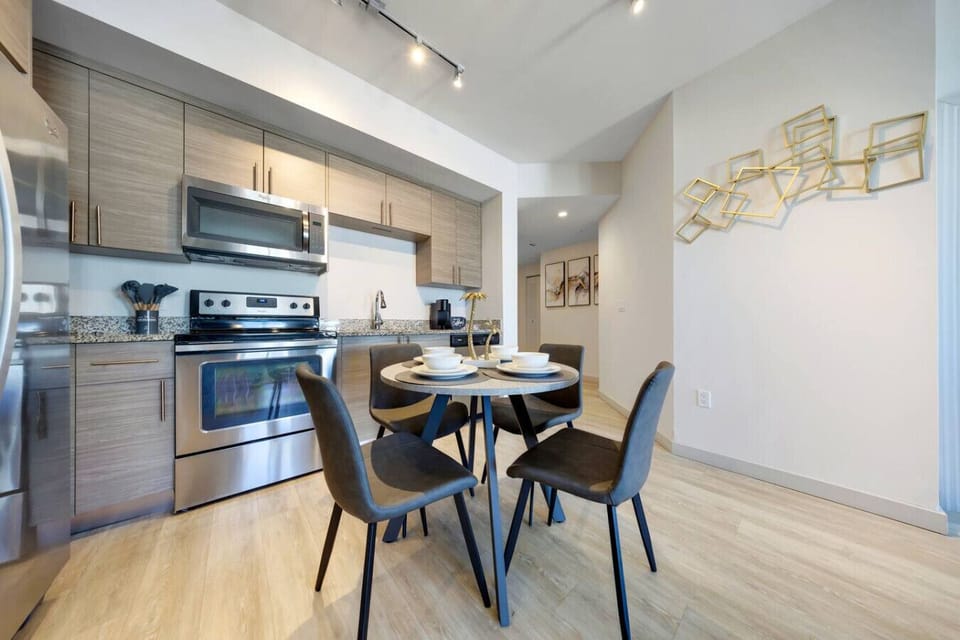 Stylish Kitchen & Dining Area-Fully equipped kitchen with stainless steel appliances, granite countertops, and ample cabinet space. Cozy dining table set for four, perfect for meals or casual gatherings.