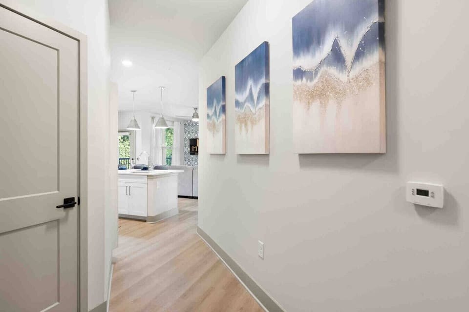 Stylish Hallway Entrance-Bright hallway with modern artwork leading into the open kitchen and living area. Warm wood flooring and clean lines create a welcoming first impression.