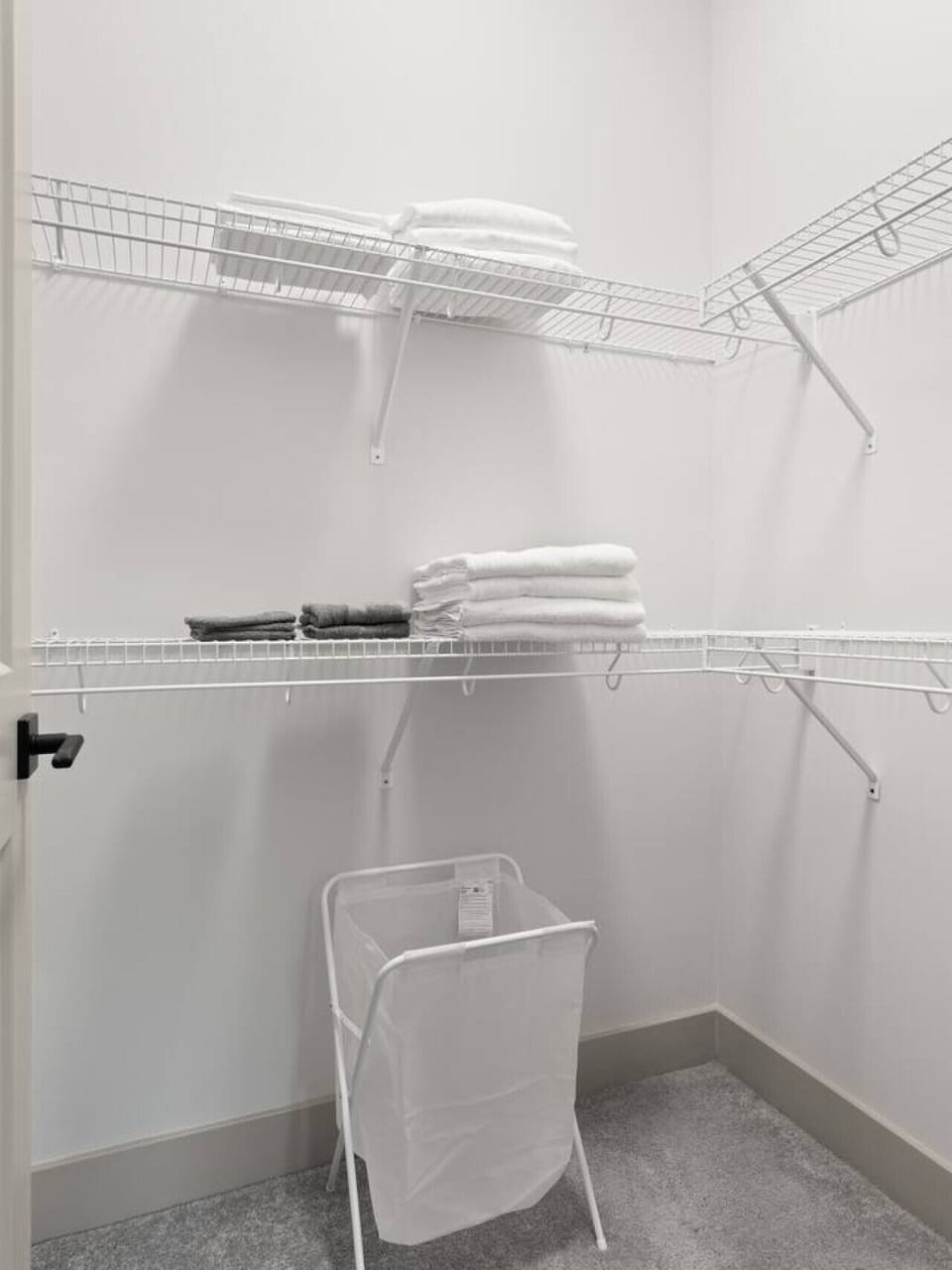 Spacious Walk-In Closet-Ample storage with wire shelving and fresh linens neatly arranged. Includes a laundry basket, making it easy to stay organized during your stay.