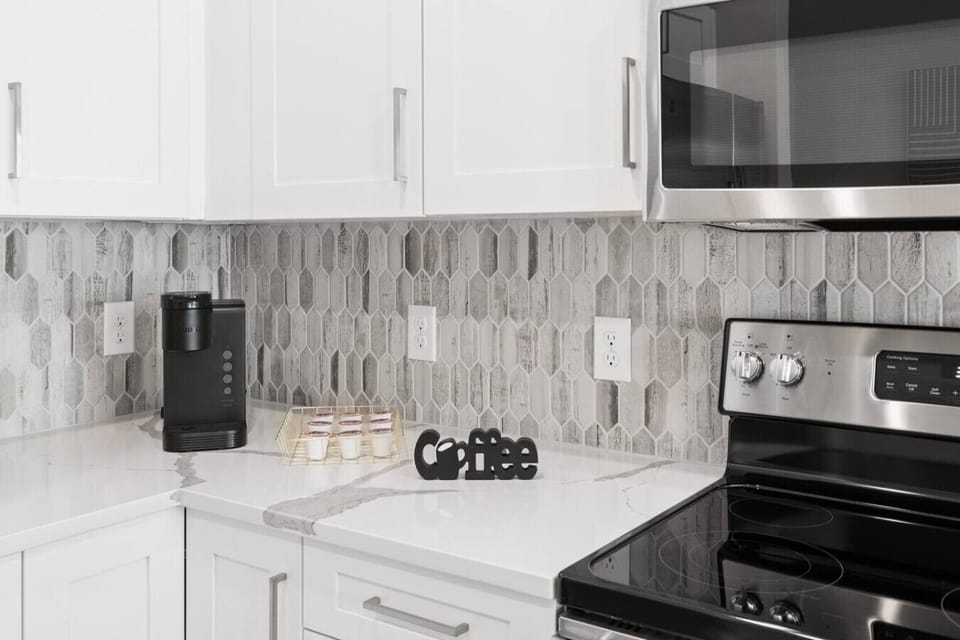Coffee Station Corner – Convenient kitchen setup with a Keurig machine, K-Cup selection, and modern backsplash. Perfect for starting the day with fresh coffee in a stylish, well-equipped space.