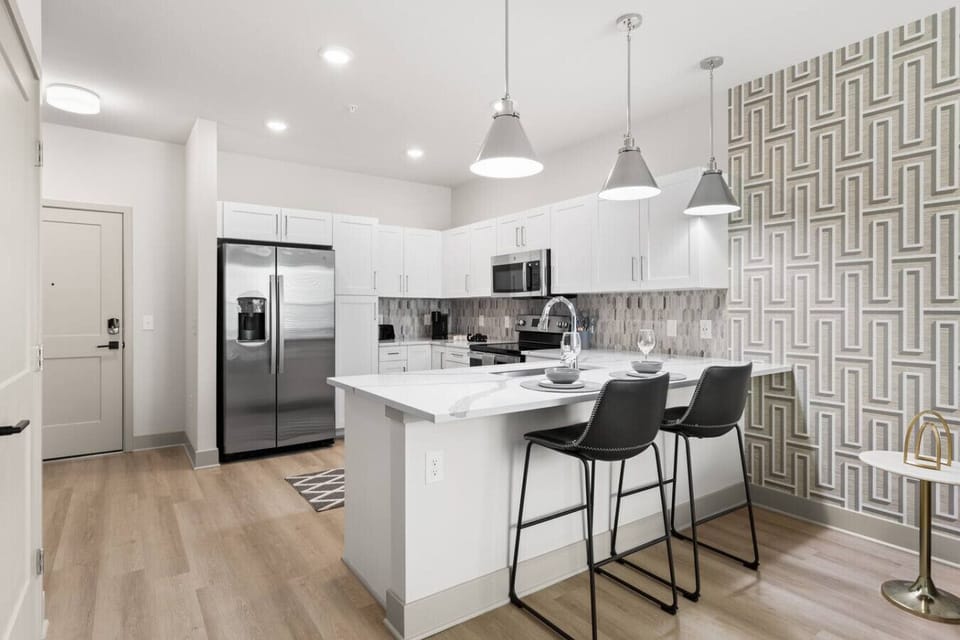 Stylish Kitchen & Bar – Modern space with stainless steel appliances, white cabinetry, and quartz island. Pendant lighting and bar seating make it perfect for casual dining or entertaining in style.
