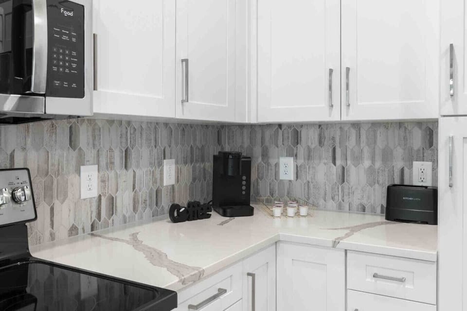 Coffee Station Corner – Convenient kitchen setup with a Keurig machine, K-Cup selection, and modern backsplash. Perfect for starting the day with fresh coffee in a stylish, well-equipped space.