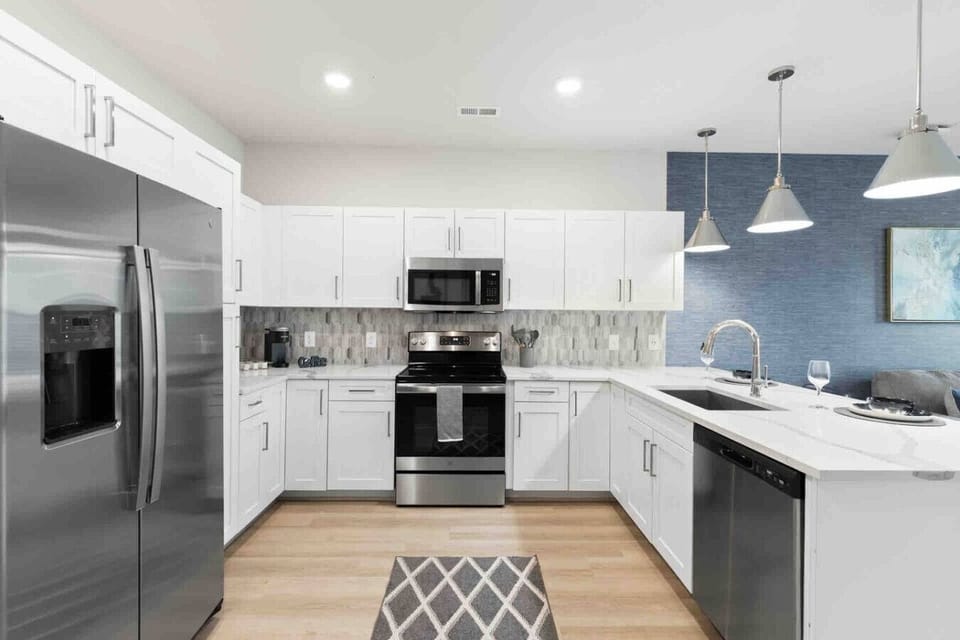 Modern Kitchen – Sleek space with stainless steel appliances, white cabinetry, and quartz countertops. Stylish backsplash and open layout make cooking and entertaining both easy and enjoyable.