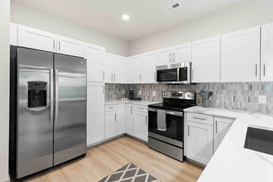Modern Kitchen – Sleek space with stainless steel appliances, white cabinetry, and quartz countertops. Stylish backsplash and open layout make cooking and entertaining both easy and enjoyable.