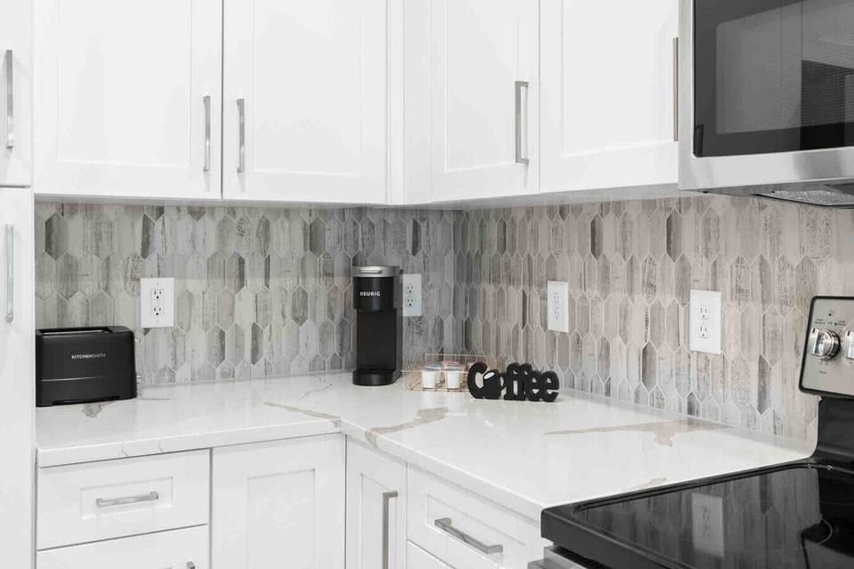 Coffee Station Corner – Convenient kitchen setup with a Keurig machine, K-Cup selection, and modern backsplash. Perfect for starting the day with fresh coffee in a stylish, well-equipped space.