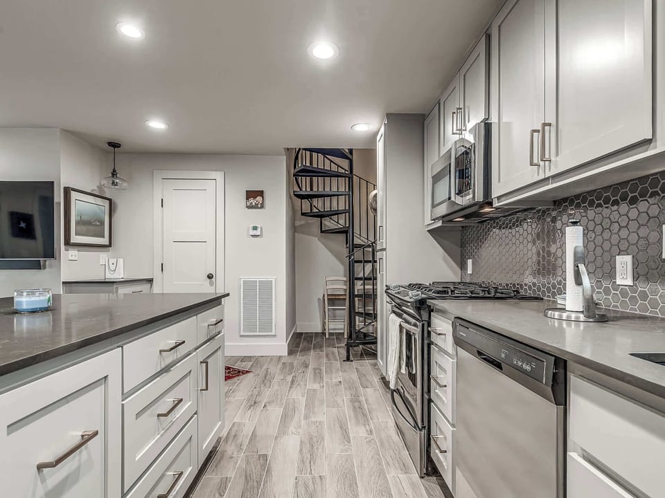 The guest house kitchen is fully stocked for all your cooking needs, featuring a full-size refrigerator, oven, and microwave. The modern design and layout make meal prep a breeze.