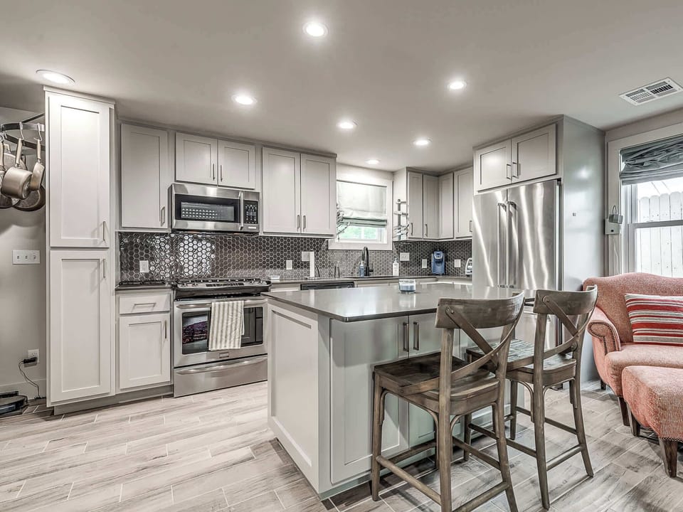 The open-concept kitchen and living area is perfect for socializing. The modern kitchen with a large island and high-end appliances flows seamlessly into the living space, creating a perfect hub for your stay.