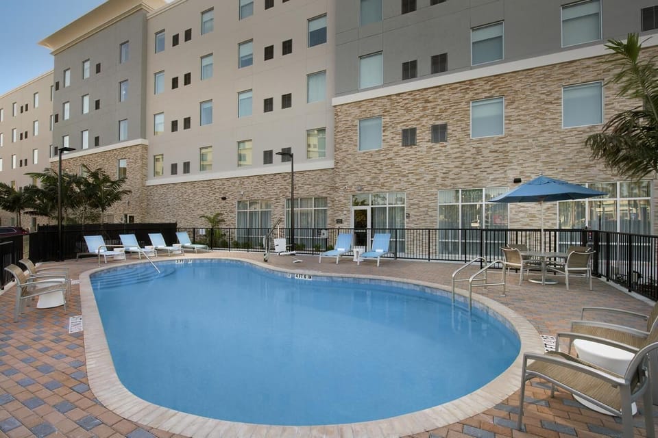Dive into sunlit relaxation beside the sparkling outdoor pool.
