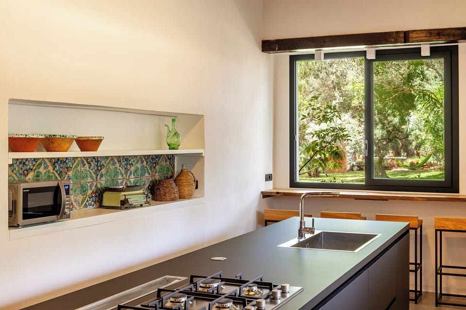 The contemporary kitchen incorporates antique tiles for a bit of colour.