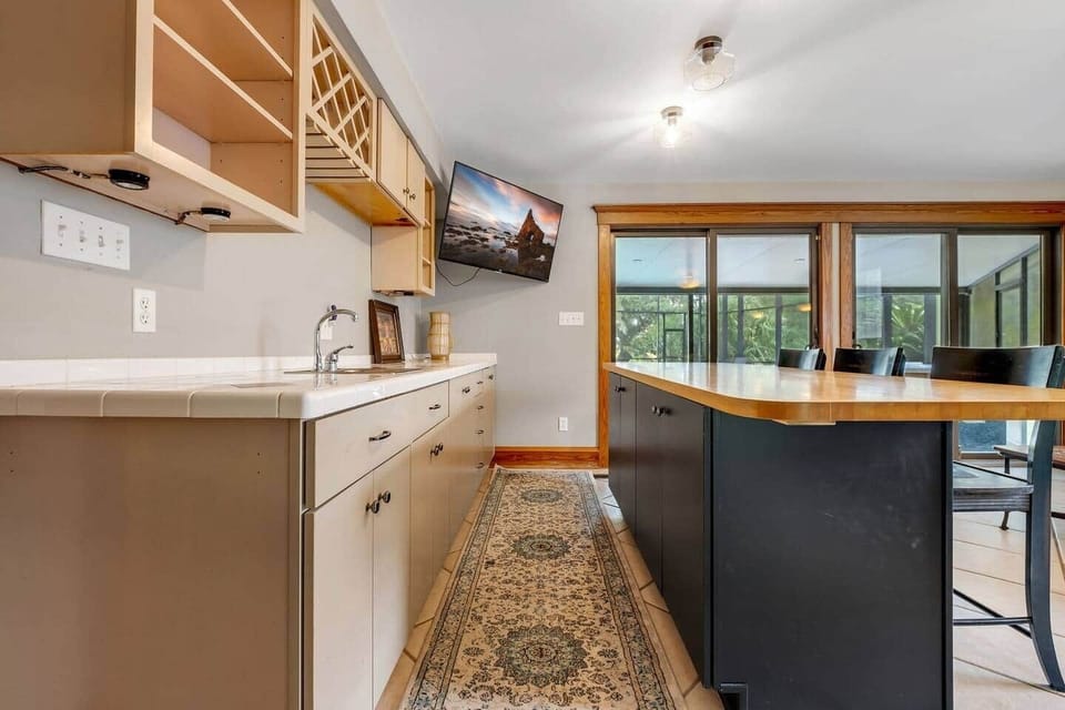 The MAN CAVE... or multipurpose room.  Has bar, additional fridge, sink, seating, table for 4, mounted TV and a door for privacy.