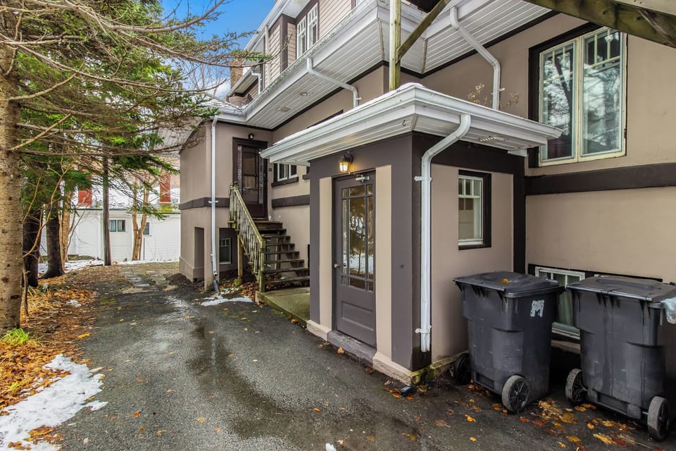 Exterior Access: View of the rear entrance and side stairs, showcasing the clean, well-maintained exterior and property layout.