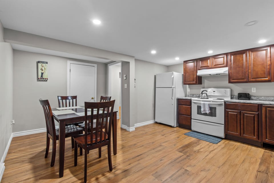 Dining Area & Kitchen: Functional open-concept layout connecting the kitchen to a four-person dining table for convenient shared meals.
