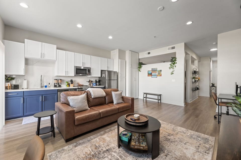 Open, modern space with full kitchen, leather sofa, and stylish, homey touches.
