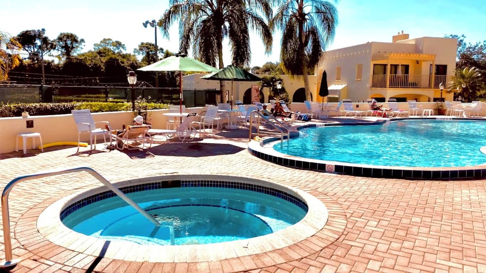 Jacuzzi and pool next to restaurant bar on property