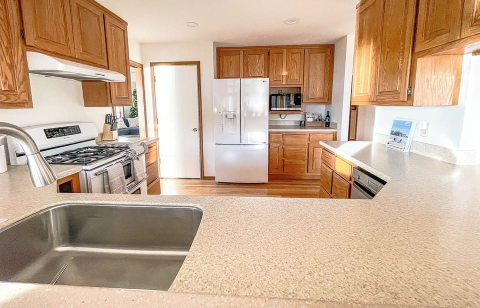 Fully-stocked kitchen with gas stove, dual ovens, and quality cookware.