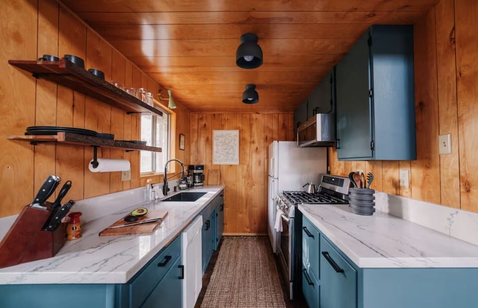 Fully equipped kitchen with a modern farmhouse sink and full appliances.