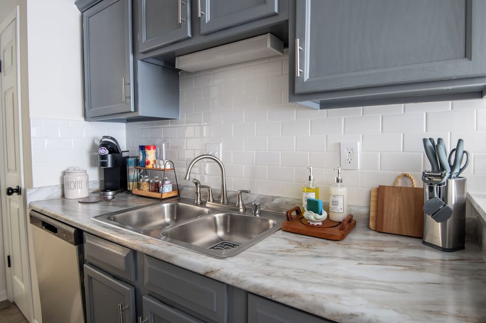 Bright kitchen sink area with modern backsplash and all the essentials within reach.