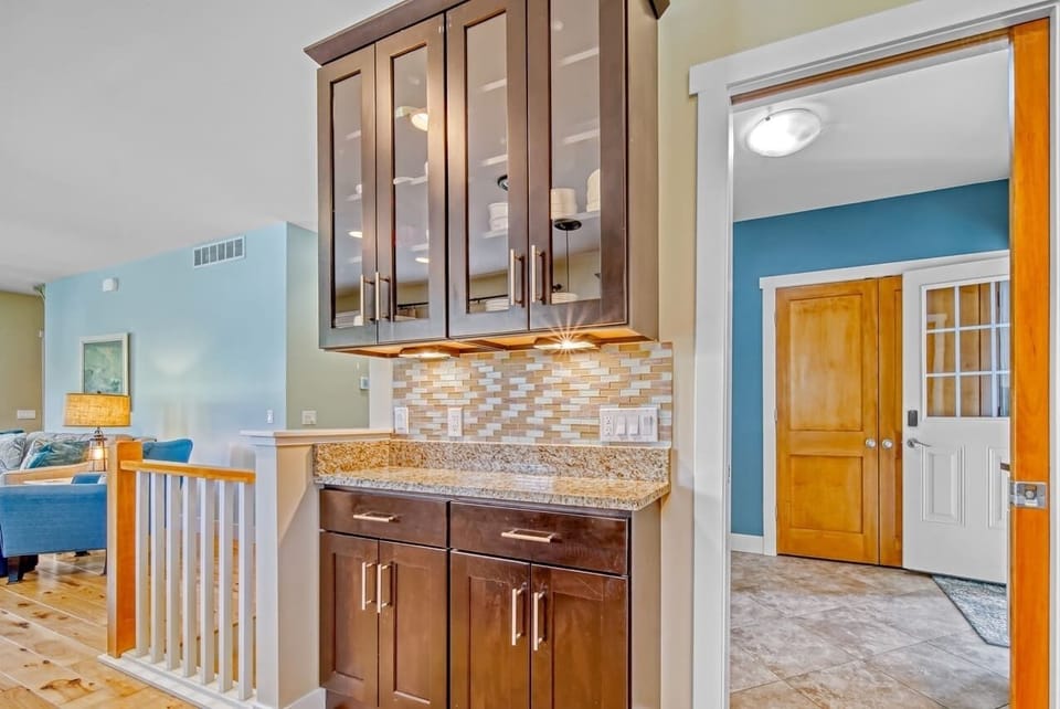 Living room has stairs to the lower level and mud room area opens to living/dining area
