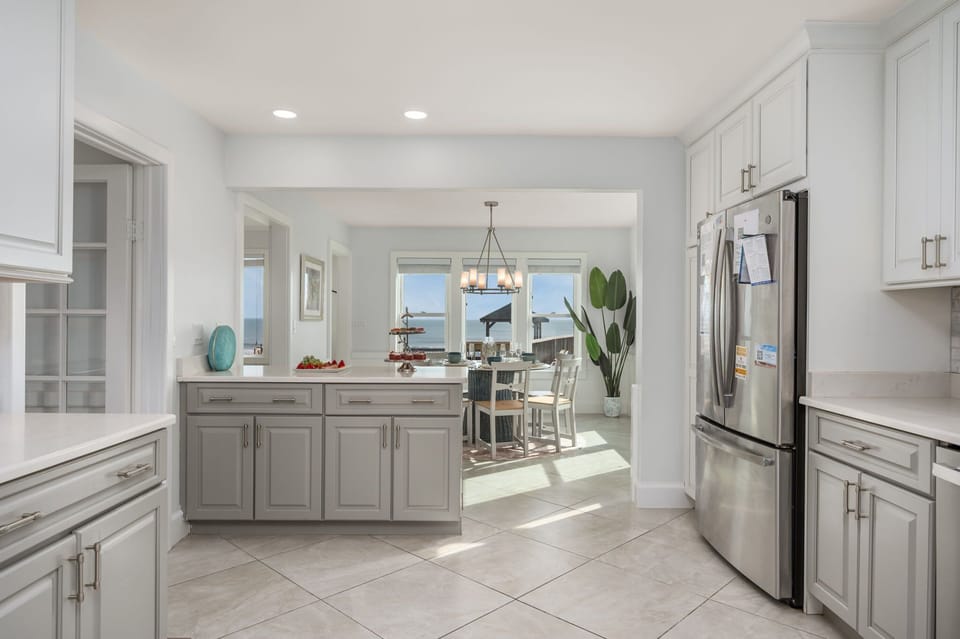 Mid Level: Fully Equipped Kitchen with ample counter space and open flow into dining area with ocean views