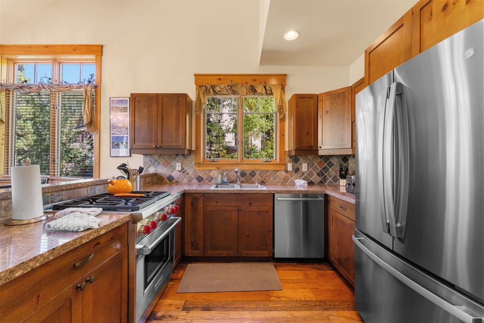 The full kitchen features granite countertops, stainless steel appliances, and breakfast bar for casual dining.