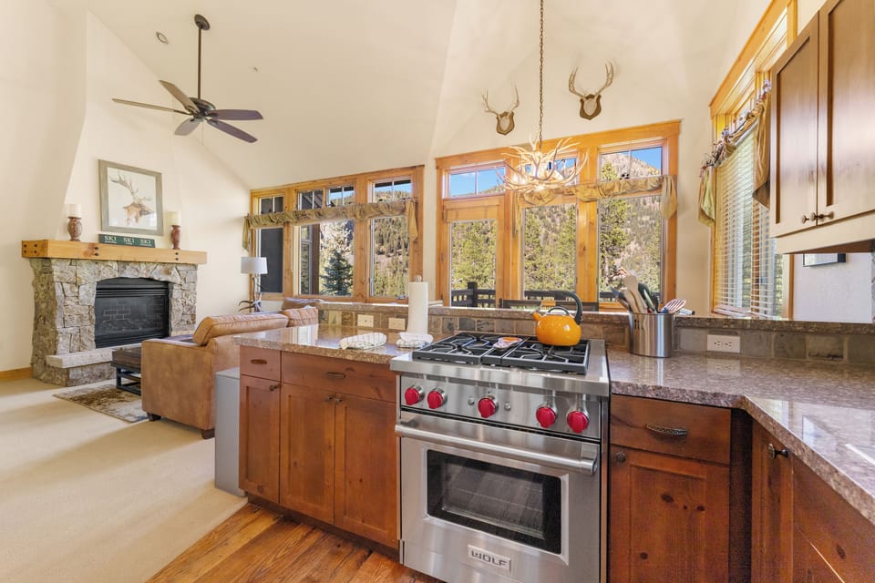 The full kitchen features granite countertops, stainless steel appliances, and breakfast bar for casual dining.