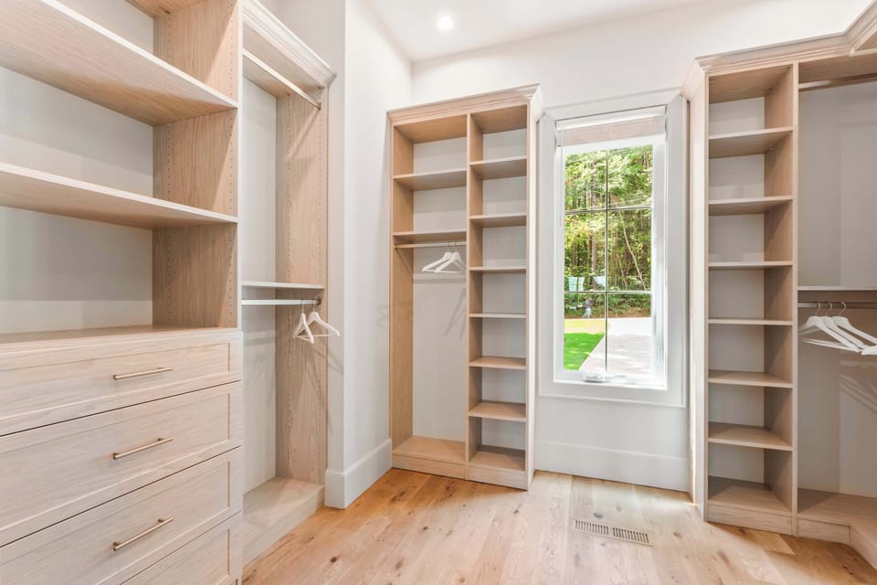 Keep clothes & bags neatly tucked away in the primary suite’s walk-in closet​