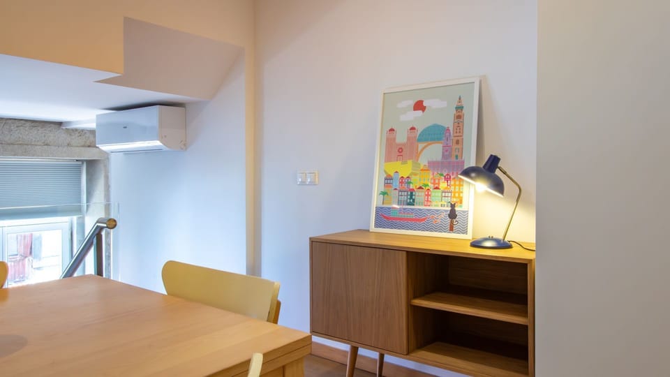 This bright space combines a dining area with a cozy corner, featuring a colorful artwork that adds a vibrant touch to the minimalist decor. #BrightLiving #CozyDining #VibrantArt #ModernDecor