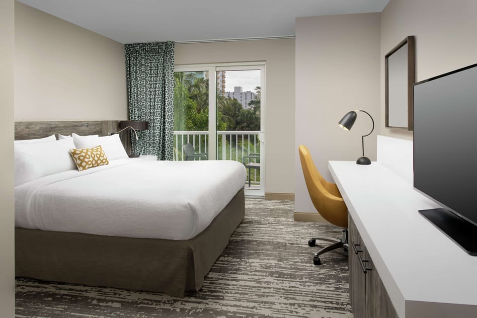 Wake up to balcony views and a calm, cozy king bed.