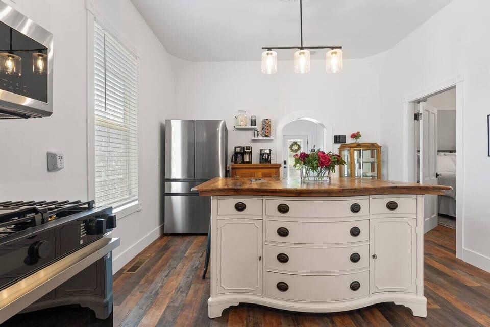 Modern convenience meets timeless character in this well-equipped kitchen, highlighted by an artisan-style island and fresh floral touches.