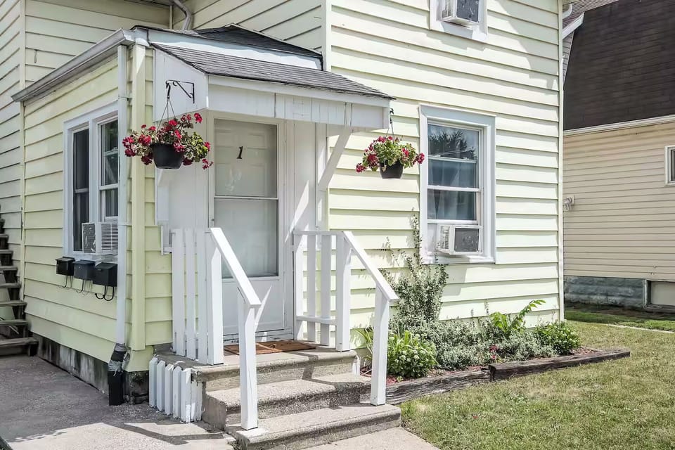 Private ground-level entrance with a welcoming porch and garden touches.