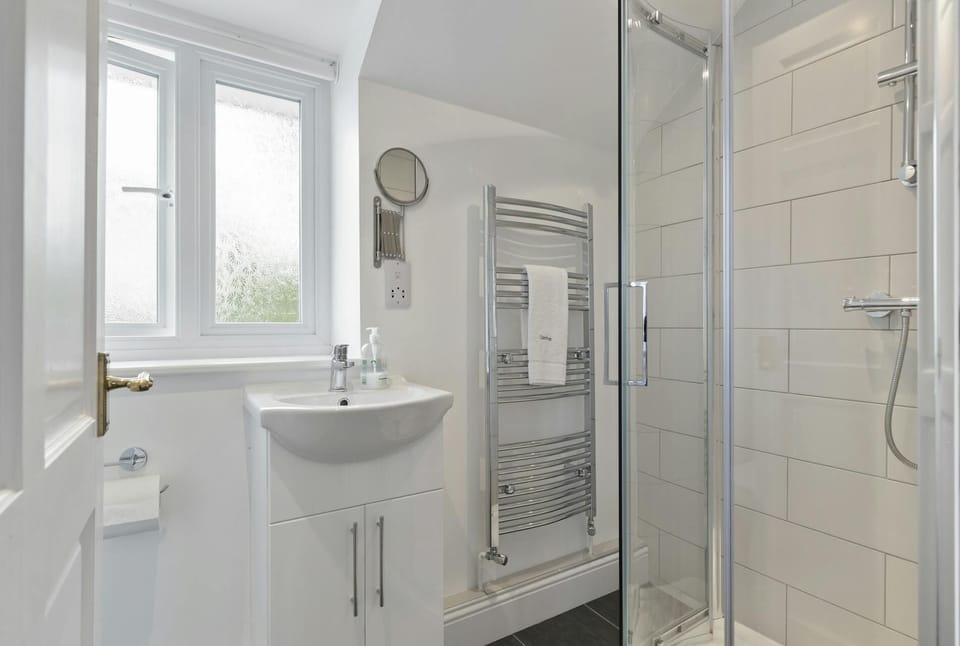 Shower cubicle, heated towel rail, wash hand basin unit with mirror over