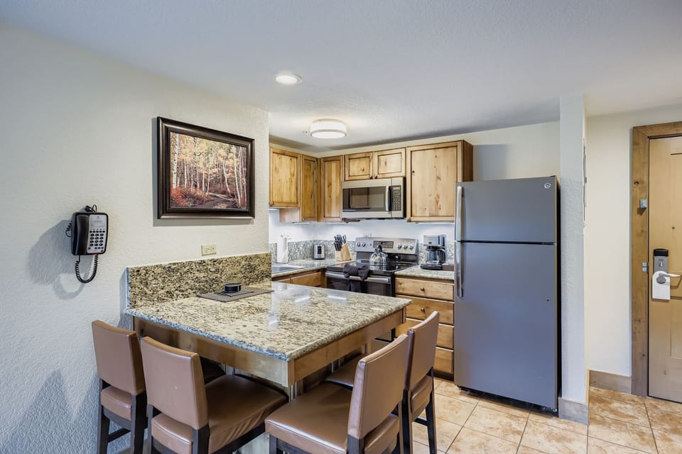 Charming Kitchen with Gleaming  Granite Countertops, Rustic Wood Cabinetry and Modern Stainless Steel Appliances
