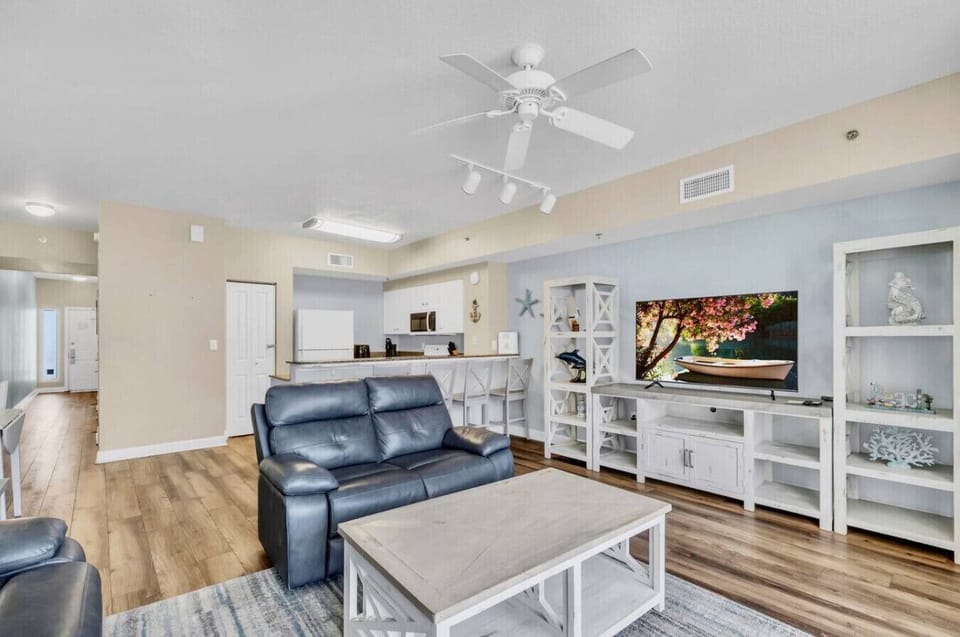 Comfortable living room with Smart TV, leather seating, and balcony access.