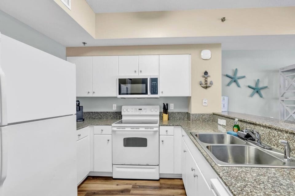 Fully equipped kitchen with granite countertops, bar seating, and all major appliances.