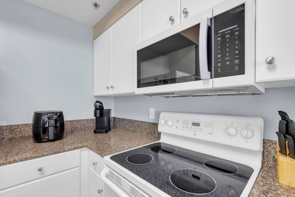 fully equipped kitchen with granite countertops, bar seating, and all major appliances.