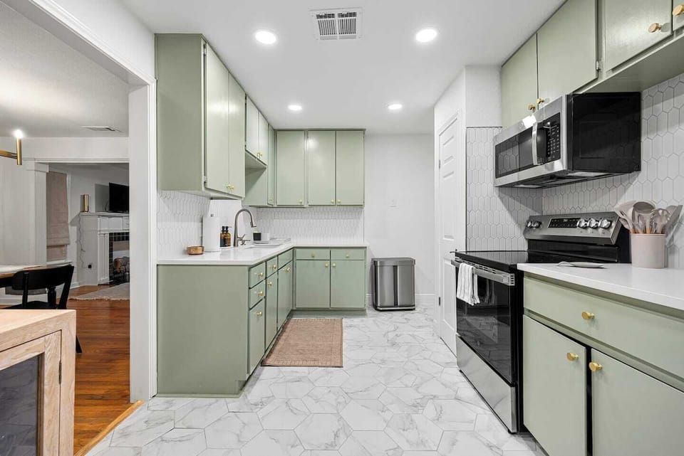 Fully equipped kitchen with stainless appliances and mint cabinetry