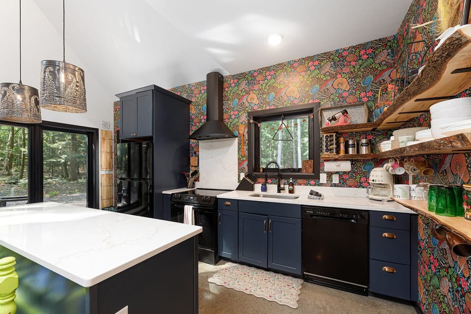 Stylish kitchen w/ sleek counters, open shelving, & vibrant backsplash details that add playful character.
